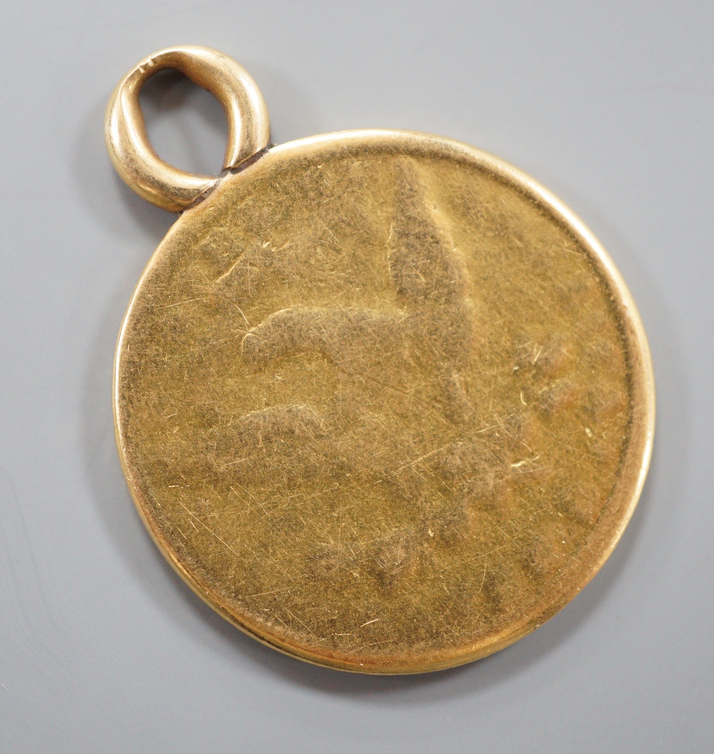 A worn gold dollar coin, now mounted as a pendant, 16.4 grams.